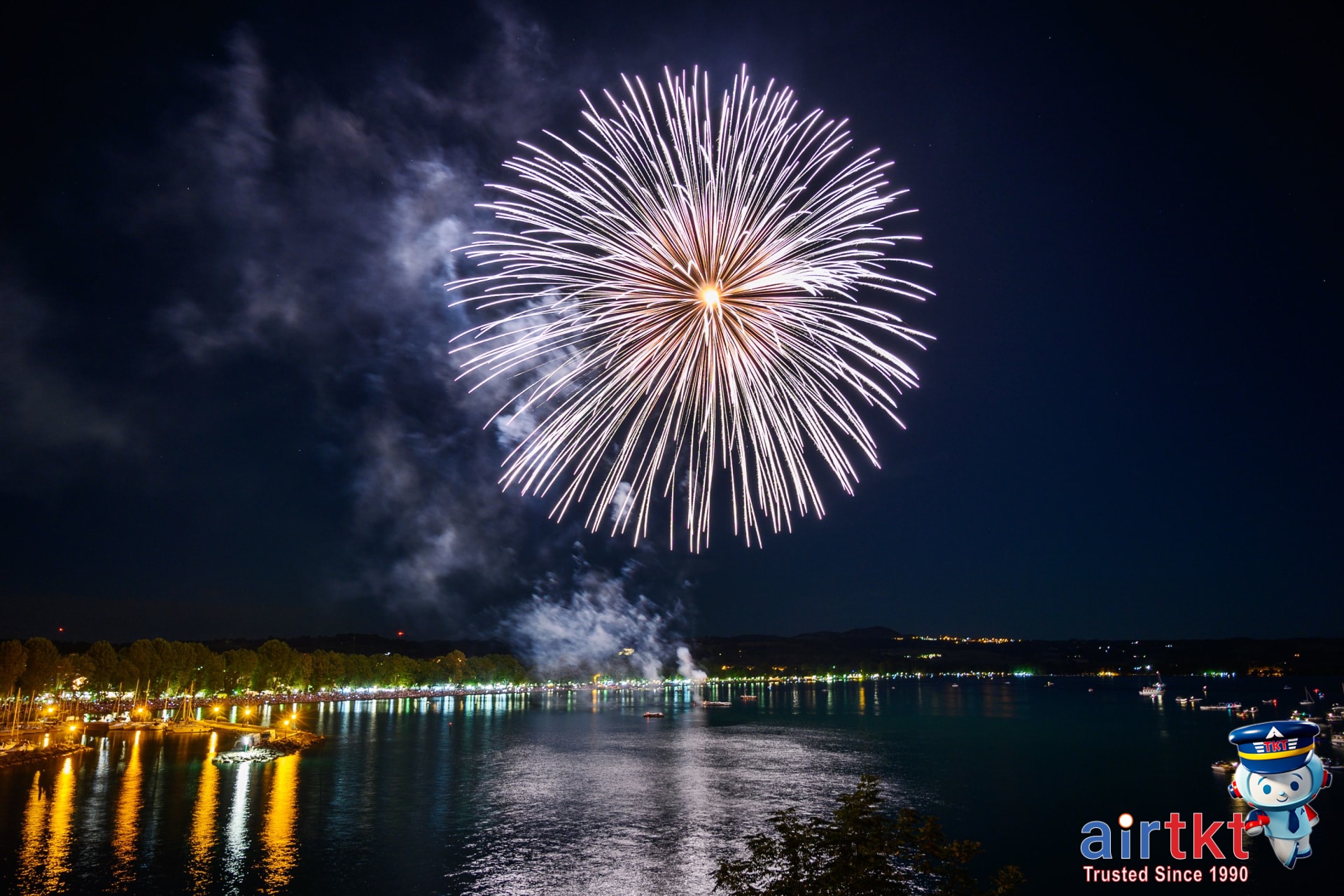 Vivid fireworks lighting the night sky reflecting on the lake in summer