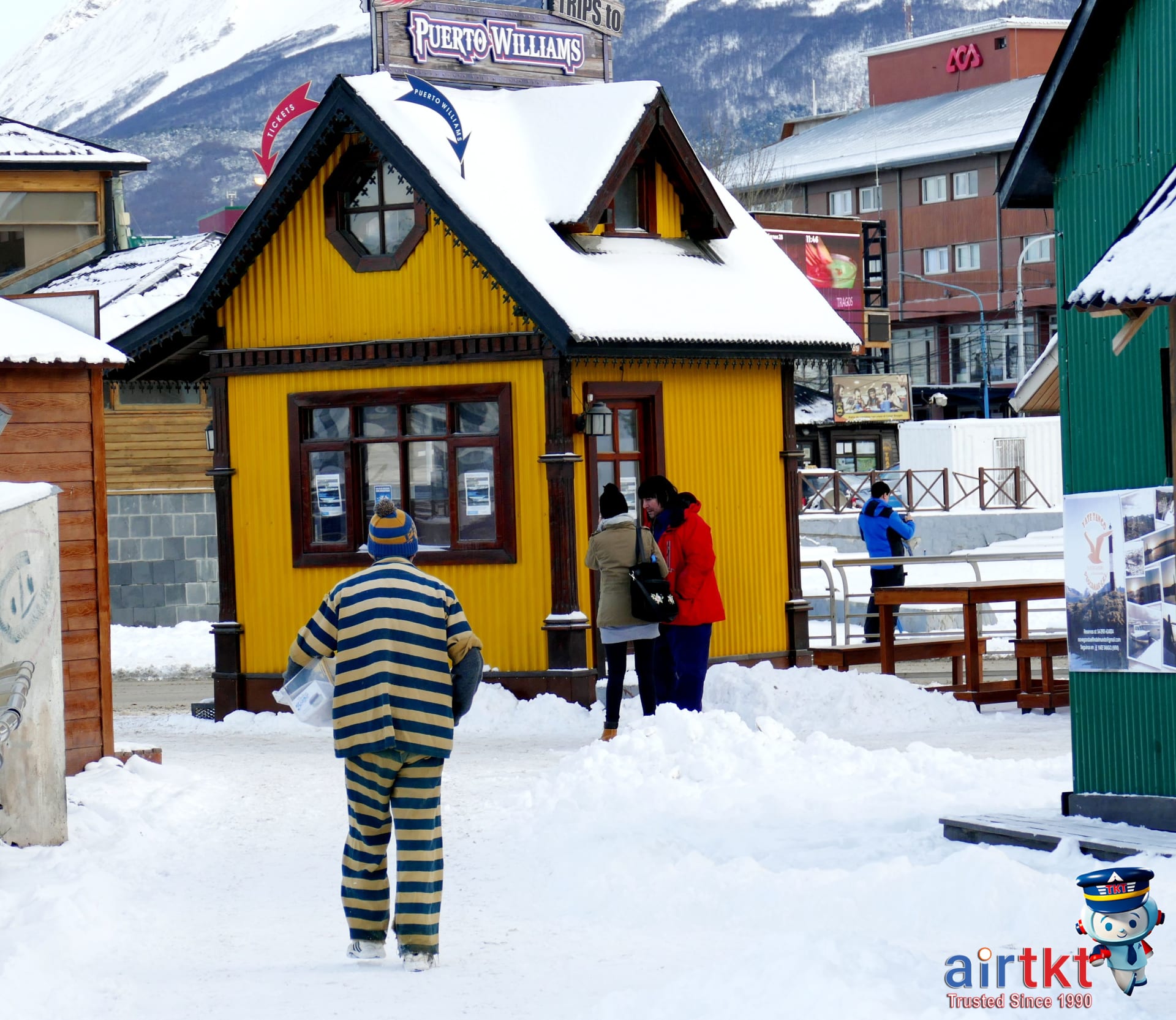 Snow-covered village street with tourists using good packing techniques for winter travel comfort