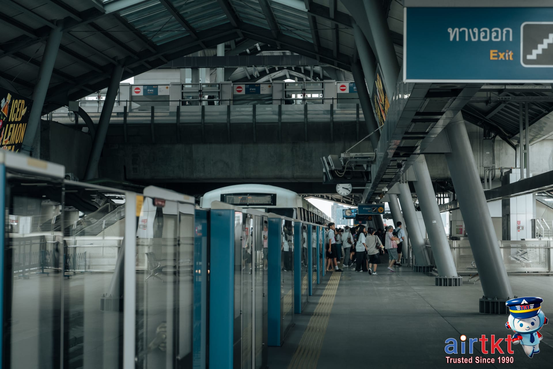 MRT train arriving at a crowded Bangkok underground station platform