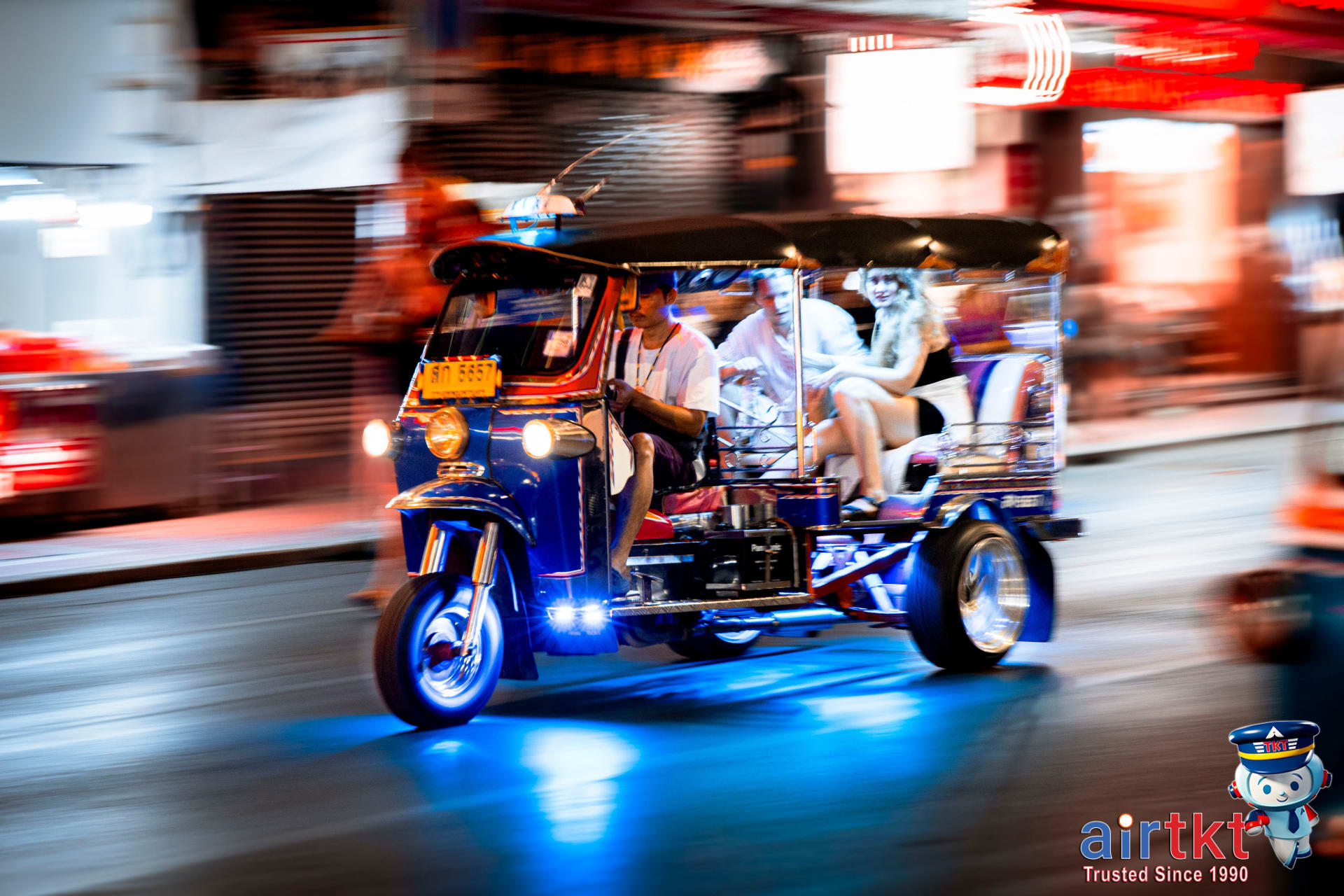 Tuk tuk navigating through heavy Bangkok street traffic during daytime