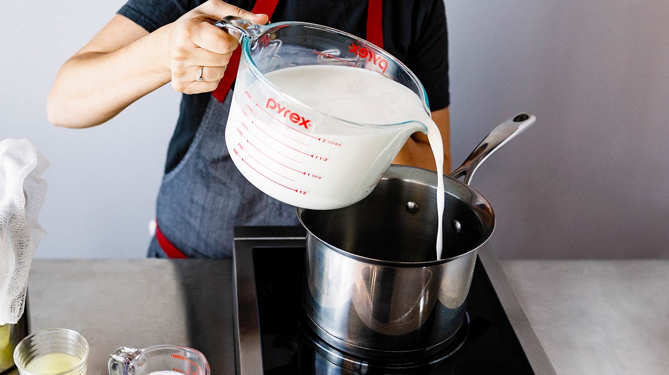 Amoretti Recipe: Homemade Ricotta. Pouring milk and cream in saucepan.
