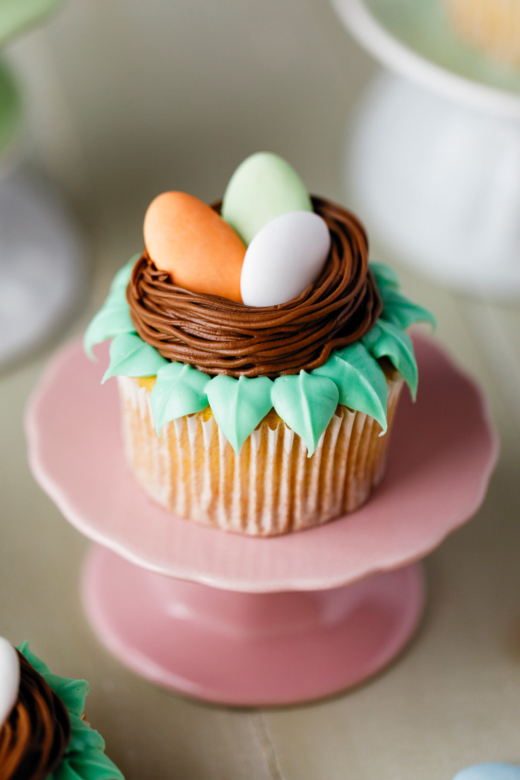 Amoretti Pistachio Cupcakes Recipe with Dragee Nests on pink pedestal