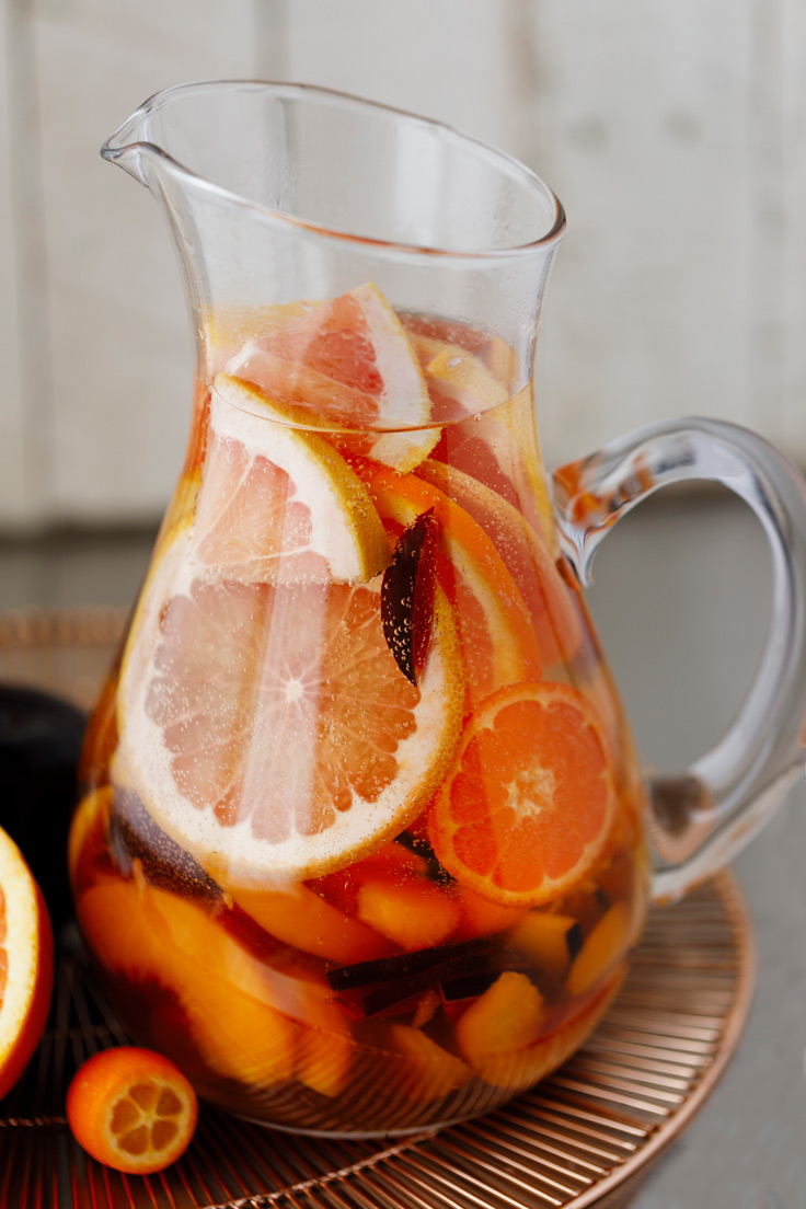 A pitcher of Amoretti Summer Sangria Recipe with stone fruits and citrus