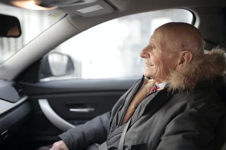 An old man sitting in his car