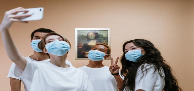 Four masked-on people clicking selfie
