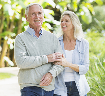 A couple laughs as they walk outside