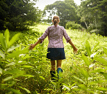 woman walks through a field