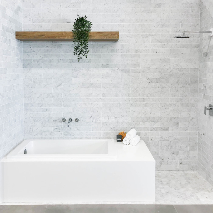 Tub Surround: Magnifica® Porcelain in Pure White | Walls: White Carrara 3x12 marble subway tile | Floor: White Carrara 2" hexagon marble mosaic tile