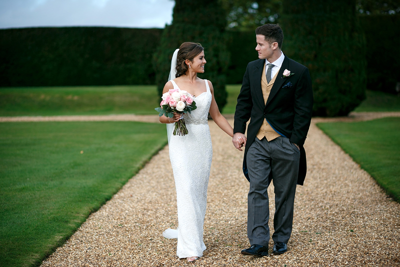 Bridebook.co.uk- bride groom walking in gardens and holding hands