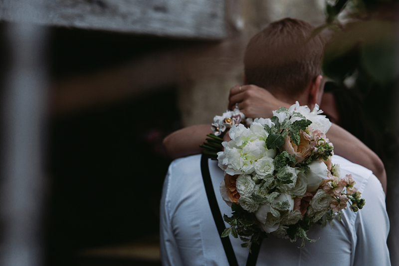 Bridebook.co.uk- bride hugging groom with the bouquet over his shoulder
