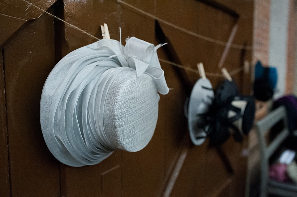 Bridebook.co.uk- ladies hats hanging up on pegs at reception