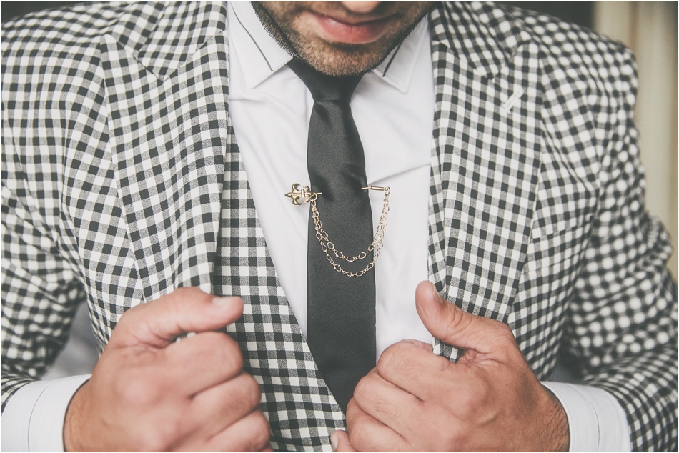 Bridebook.co.uk- groom in chequered suit with an ornate tie pin
