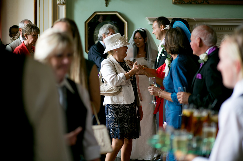 Bridebook.co.uk- guest being greeted by bride groom and parents