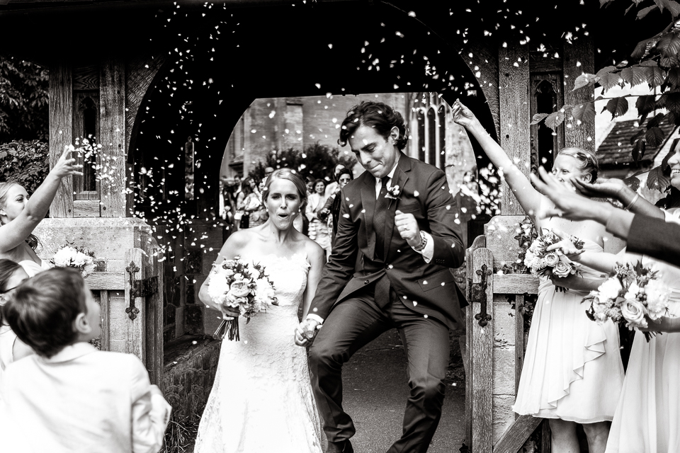 Bridebook.co.uk- groom jumping in the air as bride and groom leave ceremony
