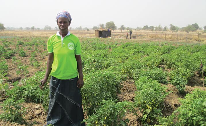 Ghanan women stands in her garden