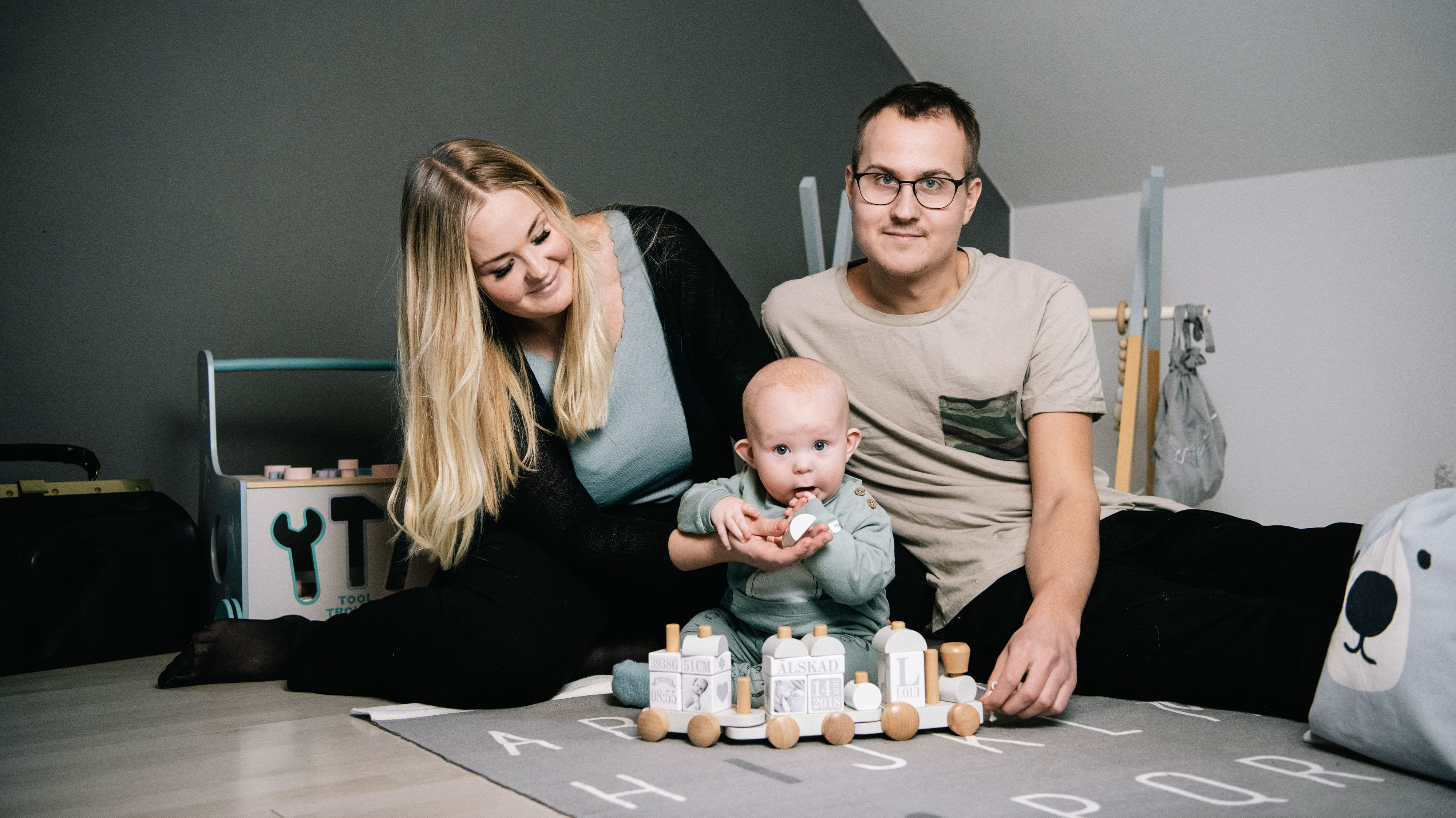 Marcus och Therése med deras son Loui på golvet med massa leksaker