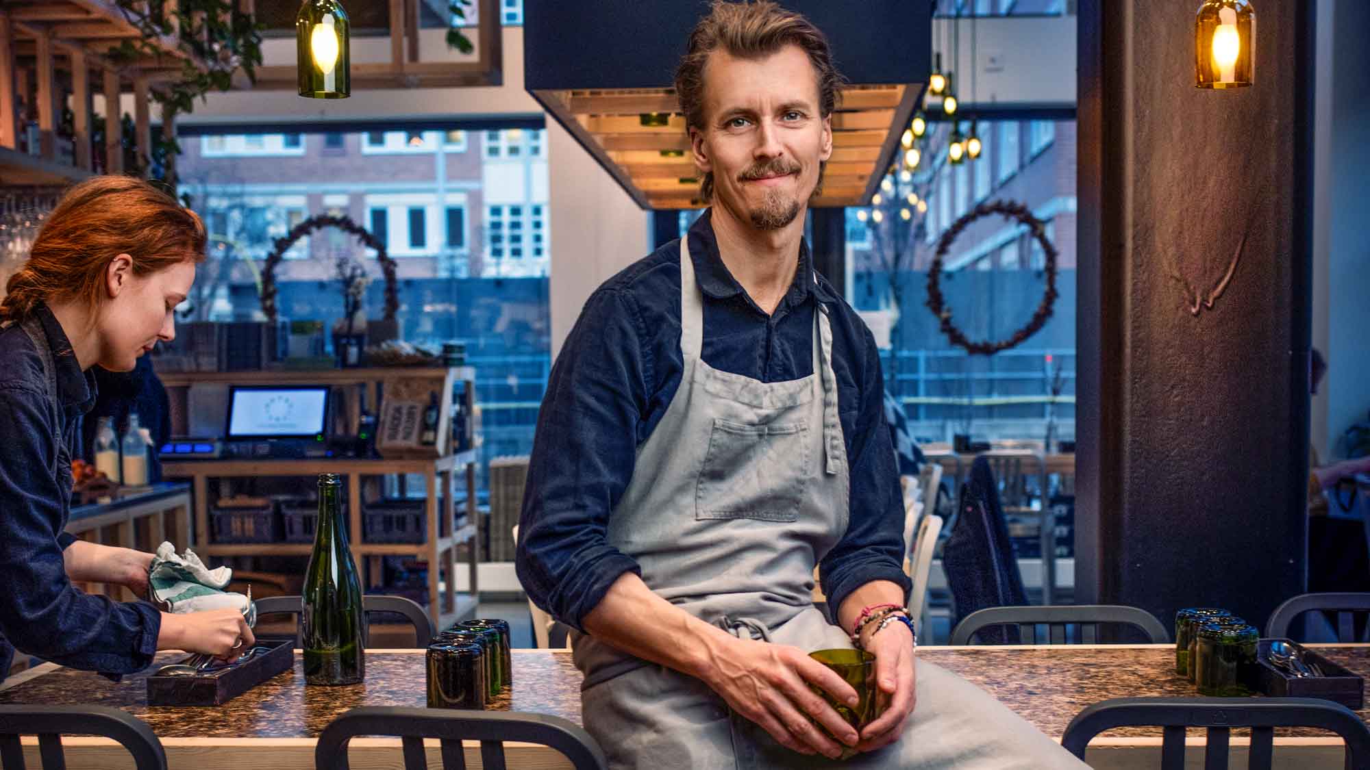 Paul Svensson sitter på ett bord i sin restaurang och tittar in i kamerna.