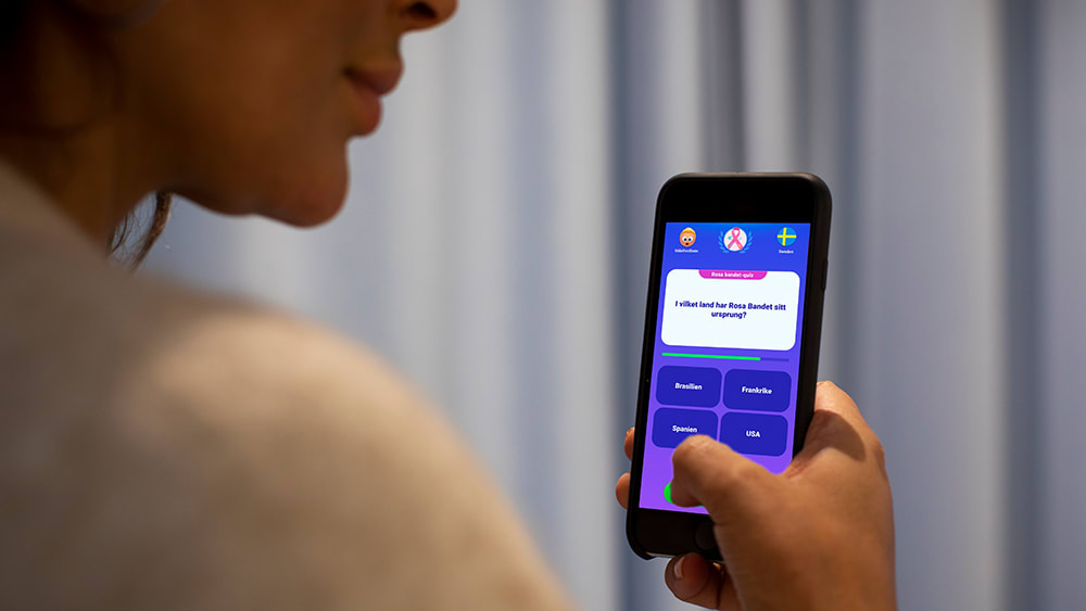 Kvinna spelar quizkampen på mobilen