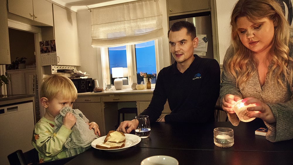 Familj hemma vid köksbordet