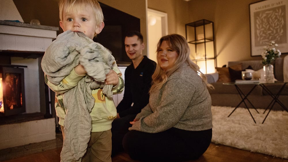 Familj hemma framför brasan