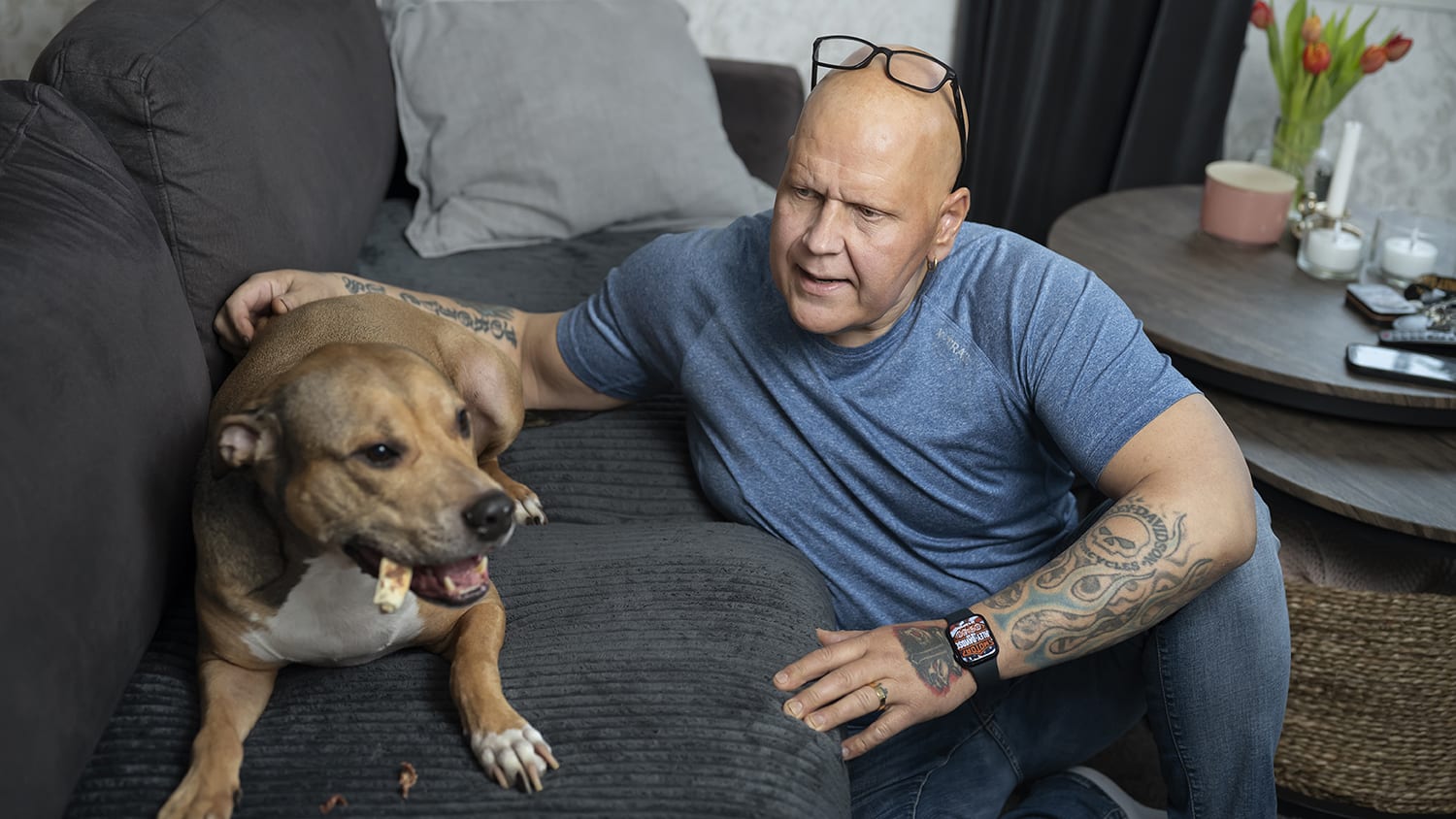 Paul på golvet, klappar hunden som är i soffan. Foto: Julia Sjöberg.