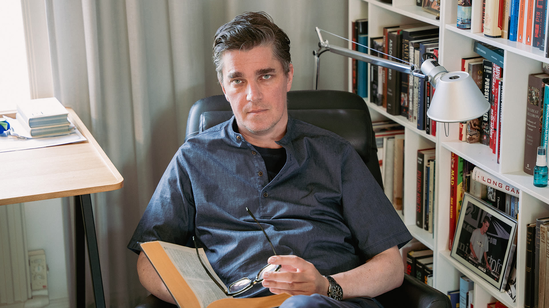 Martin Kragh sitter i en fåtölj i sitt arbetsrum.