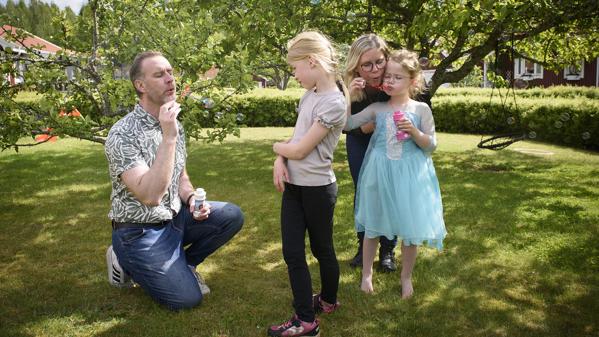 Familjen Becker Jakobsson blåser såpbubblor i trädgården. Foto: Anna Edlund.