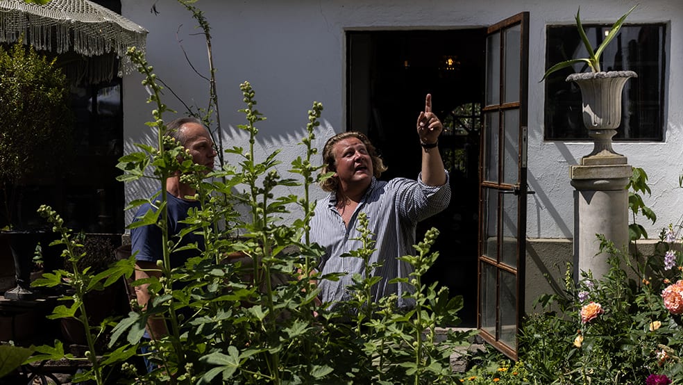 Två män tittar på ett hus och pekar