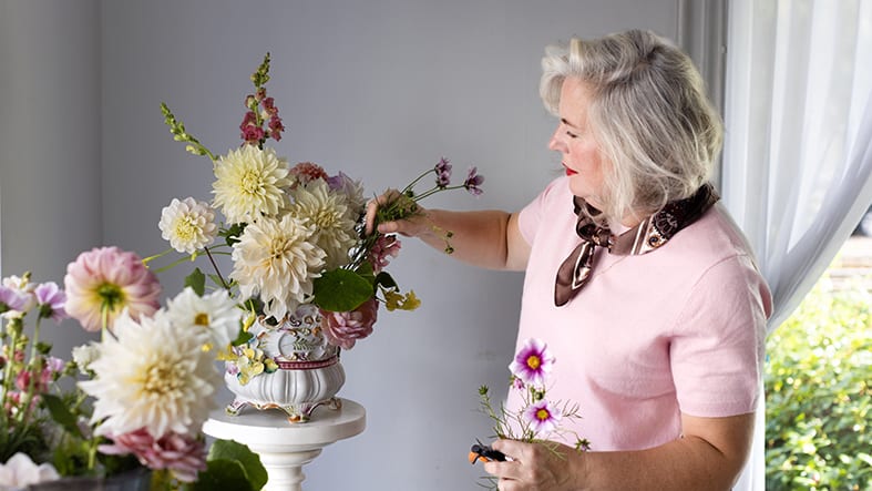 Kvinna ordnar blommor i vas