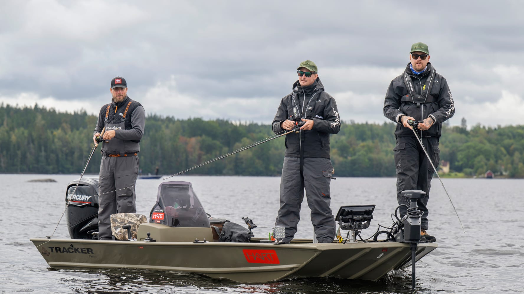 Tre män står på en båt och fiskar.