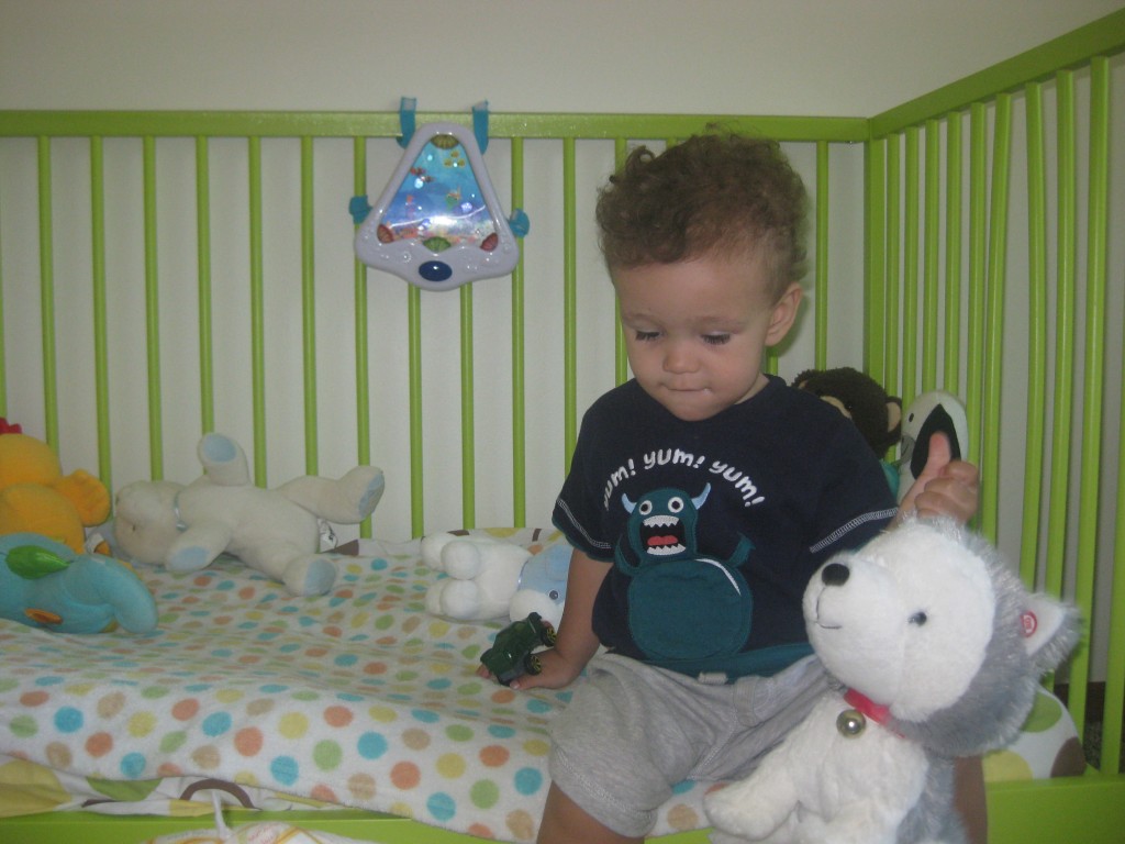 In his now converted big boy toddler bed with Jingle. (Jingle is a Hallmark product that barks, etc. at certain parts of a story. Super cute. Until you're reading the same 2 Christmas stories all year long...)