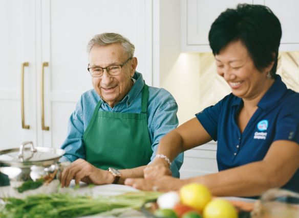 Caregiver providing in-home care services in the kitchen for a resident in La Mirada, CA