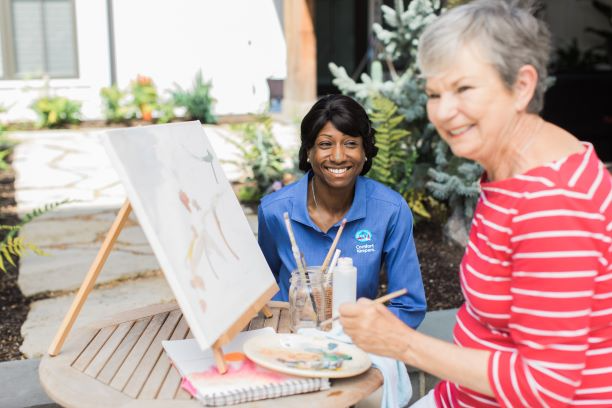 Caregiver and resident painting as part of our Interactive Caregiving. 