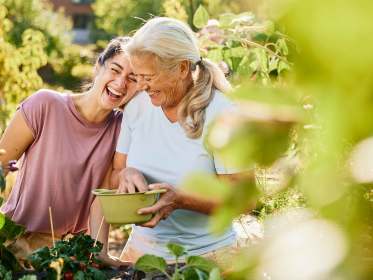 Lachende Frauen bei der Ernte im Kleingarten