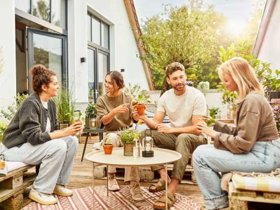 Personen sitzen zusammen auf einer Dachterrasse