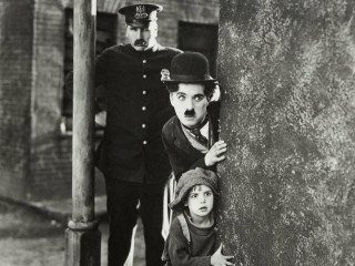 Charlie Chaplin with kid and police in the film The Kid
