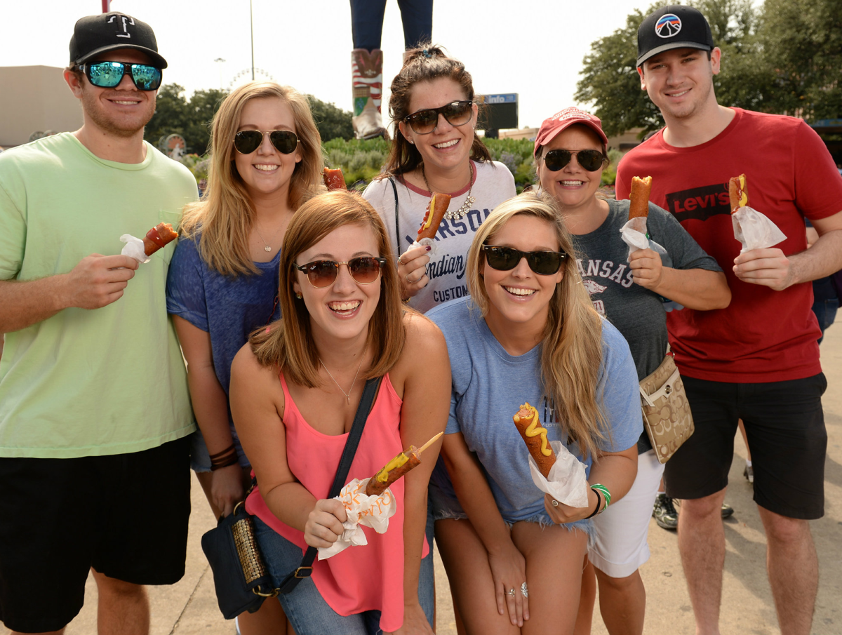 People eating corn dogs at State Fair of Texas