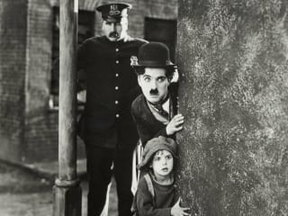 Charlie Chaplin with kid and police in the film The Kid