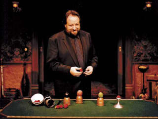 Magician Ricky Jay at table with magic and illusions stuff