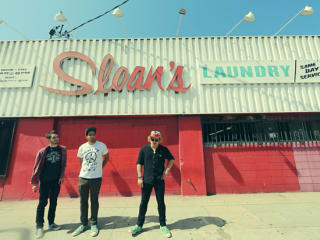 together PANGEA band standing in front of Sloan's Laundry