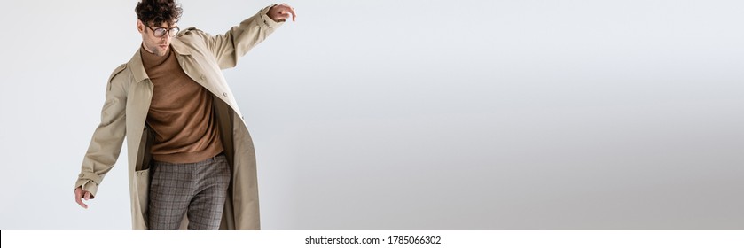 website header of fashionable man balancing while posing on grey