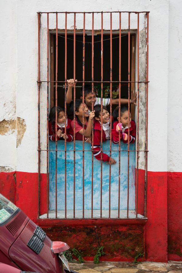 Schoolkids wait for the "Parade of the Fatties" (la Fiesta de los Panzones) in San Cristobal de las Casas, Chiapas, Mexico