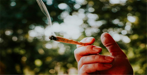 Title: person holding lighted cigarette stick