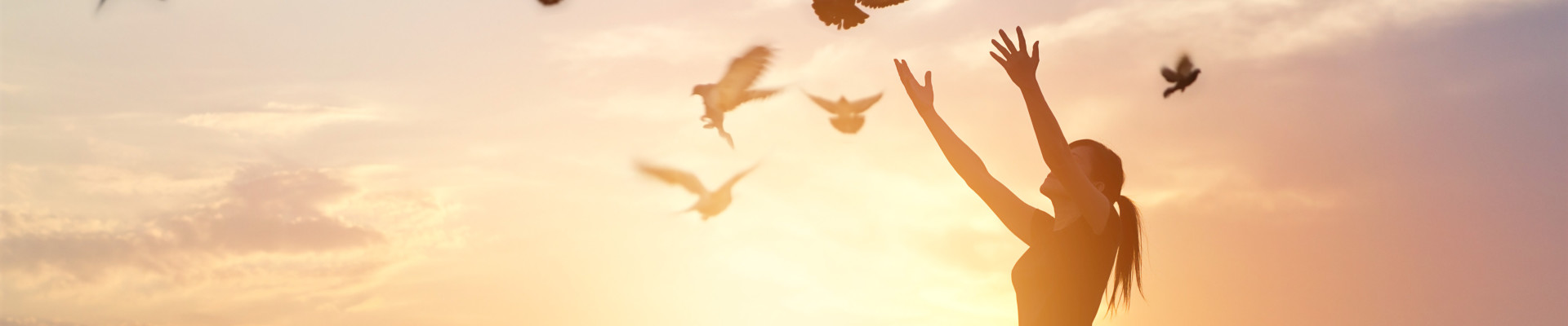 women releasing doves sunset