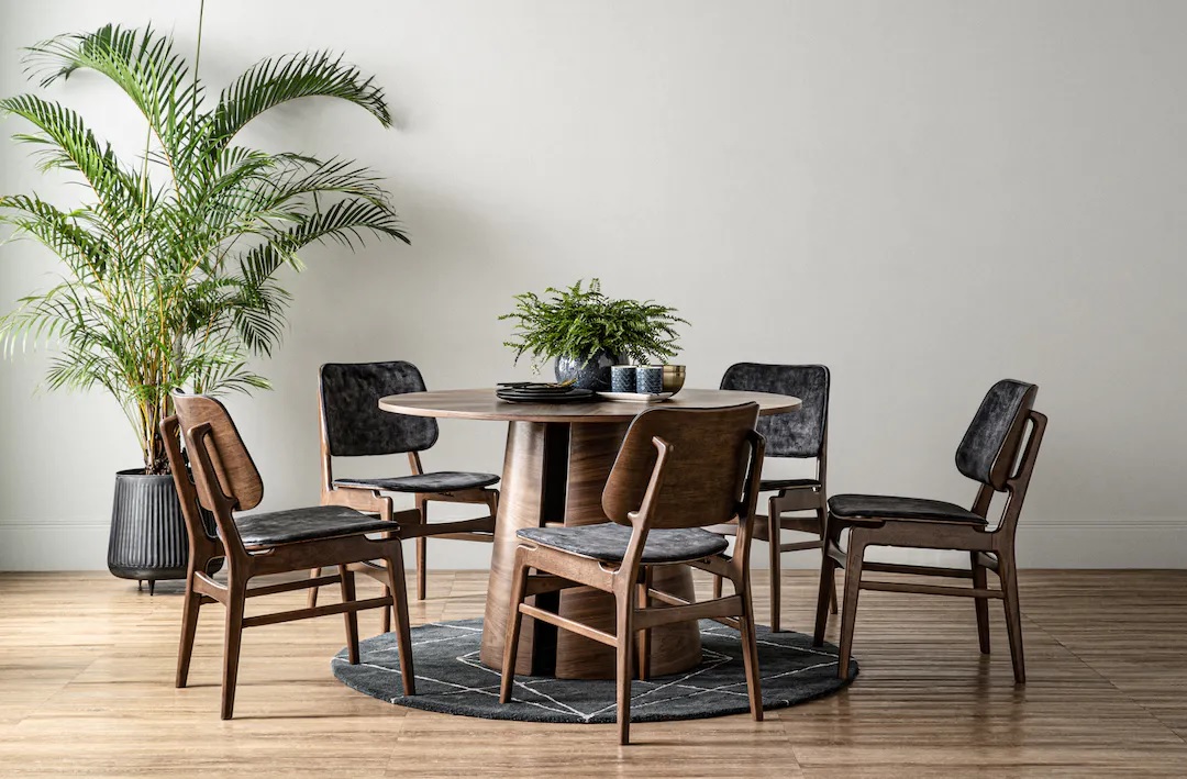 Dark brown dining table made of bentwood, with round tabletop and unique leg frame 