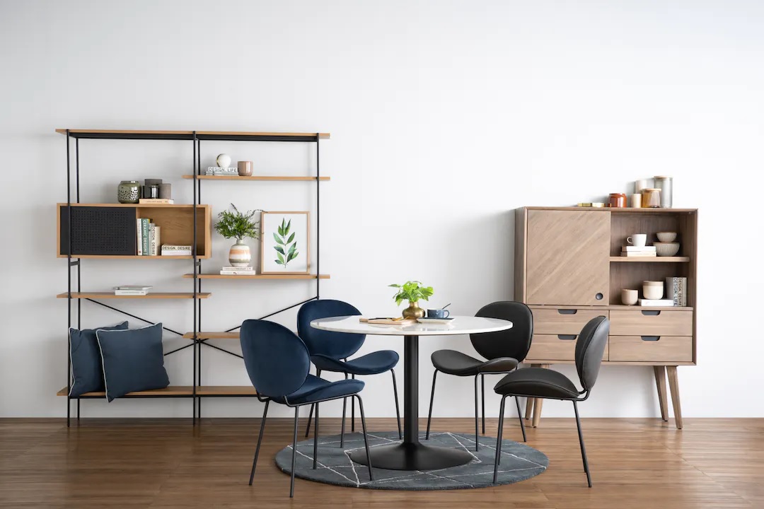 Blue and black chairs upholstered in velvet with sleek metal legs.