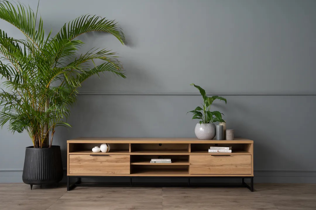 A brown TV cabinet crafted from solid wood, featuring sturdy metal legs, drawers, and open storage space