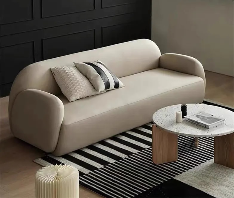 Cream fabric 3-seater sofa with curvy back and armrests, supported by carbon iron feet.