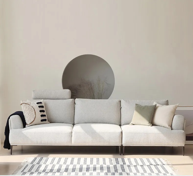 A cream-coloured 3-seater sofa made of fabric, solid wood frame, with well-stuffed backrests, and supported by carbon steel legs.