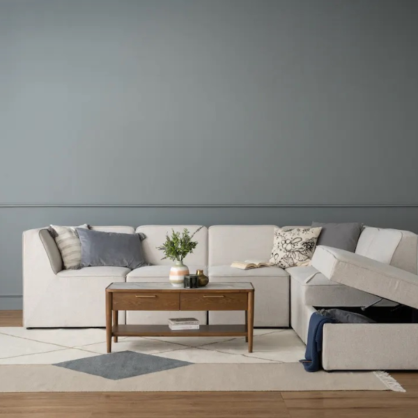 A cream-colored 4-seater L-shaped fabric sofa.
